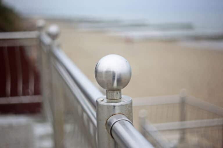 Edelstahlbau-polished-metal-ball-on-a-railing-close-up-with-blu-2025-10-14-10-37-35-utc